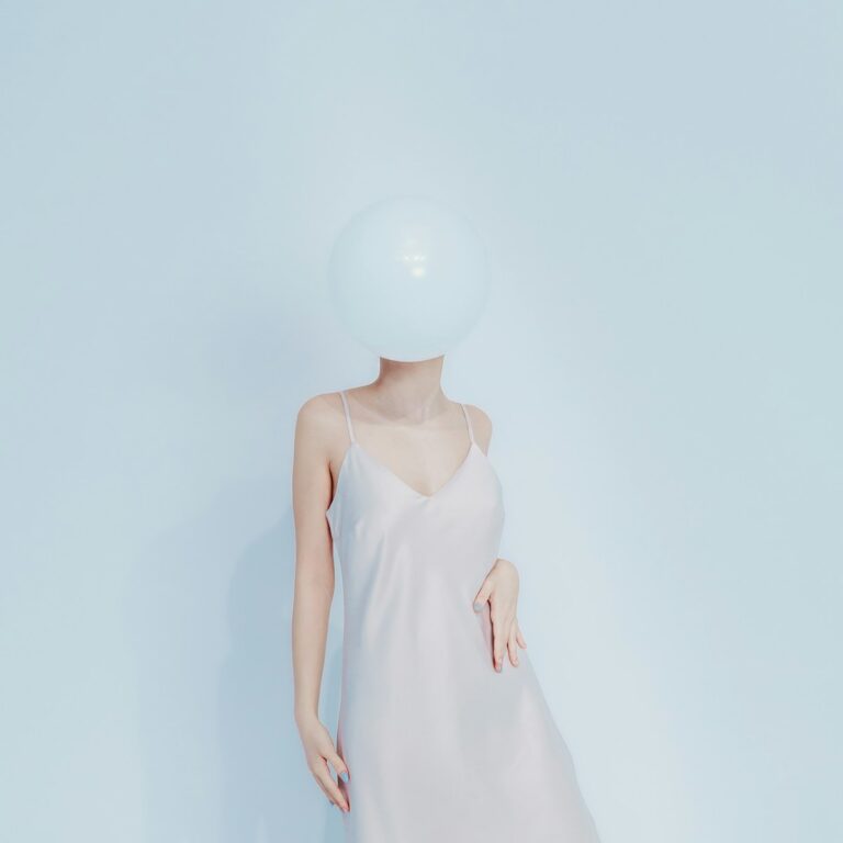 Woman in dress with balloon obscuring face